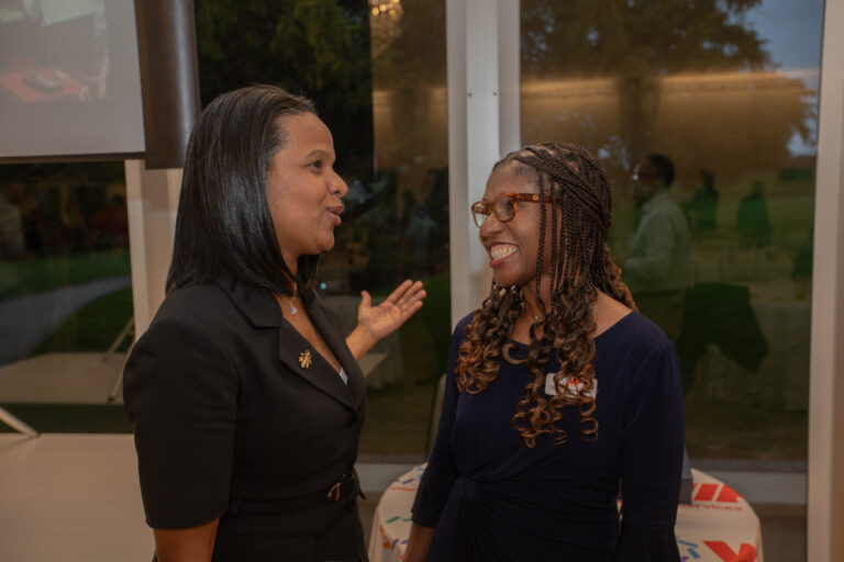 Debbian Fletcher-Blake President and CEO talks with attendee at awards dinner.
