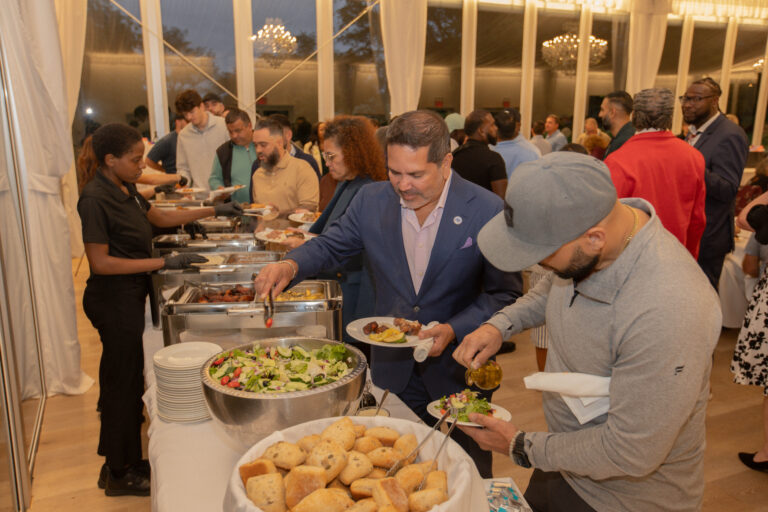 Attendees of VIP's awards dinner gather their food at the buffet.