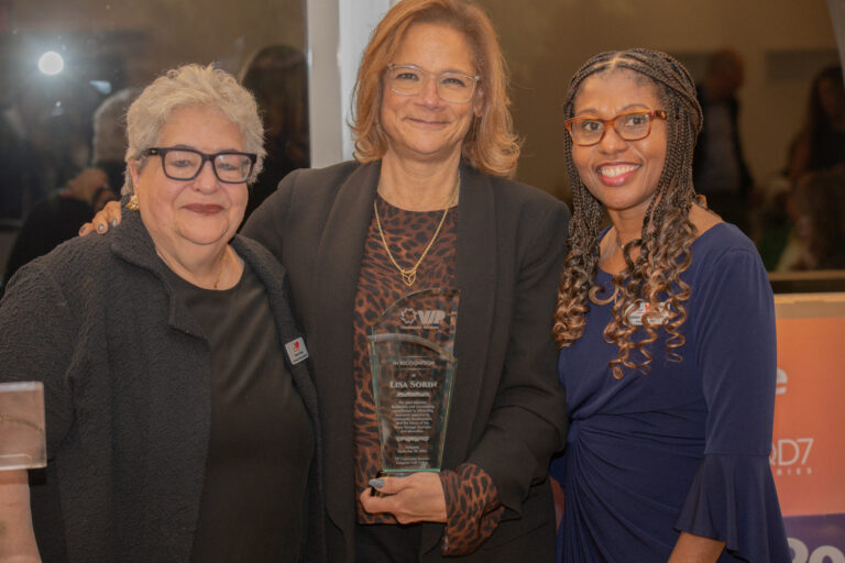 Carmen Rivera SVP / Chief Vocational & Community Affairs Officer, Lisa Sorin, President of the Bronx Chamber of Commerce, and President and CEO Debbian Fletcher-Blake, pose for photo with Lisa holding award.